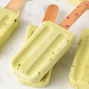 a stack of Avocado Popsicles with a wooden stick