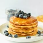 A Stack of Vegan Chickpea Flour Pancakes decorated with blueberries.