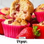 a stack of vegan strawberry muffins with a lovely golden fluffy crumb filled with juicy pieces of baked strawberries