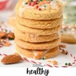 a stack of almond flour sugar cookies with royal icing and red, green, and golden sprinkles on top