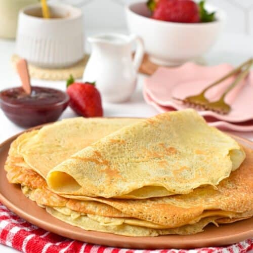 a plate filled with vegan crepes and vegan crepes toppings in the background