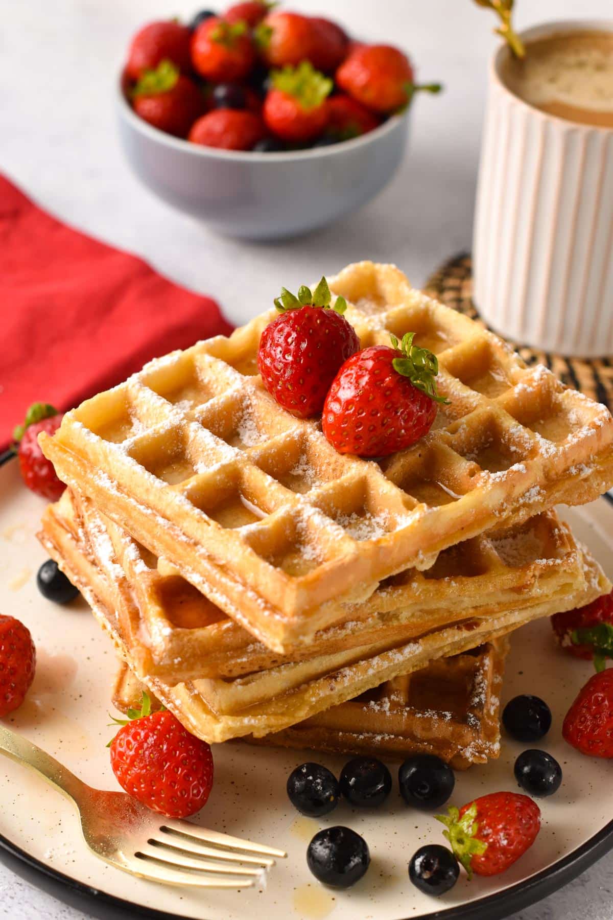 Vegan Waffles stacked and decorated with fresh raspberries.