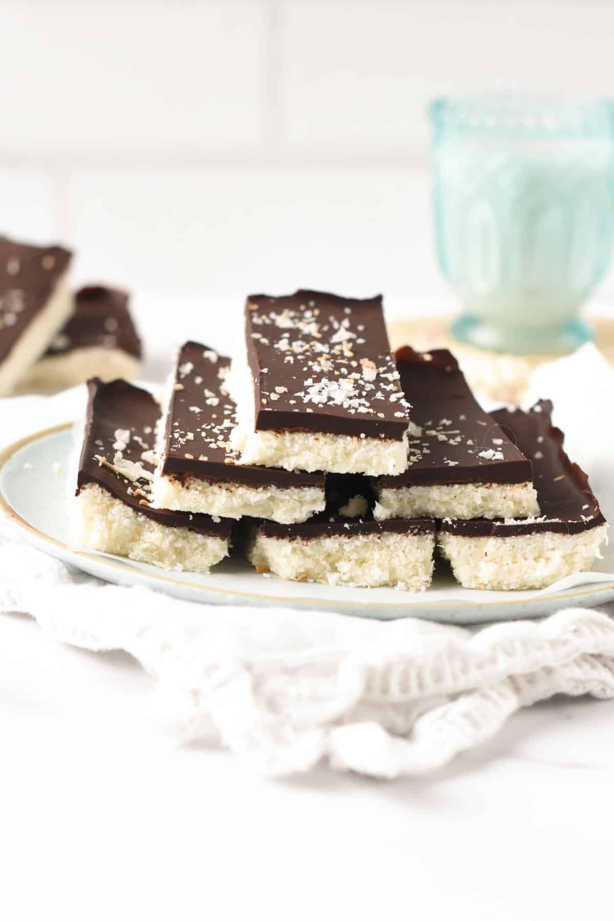 No Bake Coconut Bars stacked in a pyramid shape on a plate.