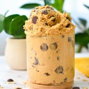 a glass jar filled with chocolate chips chickpea cookie dough