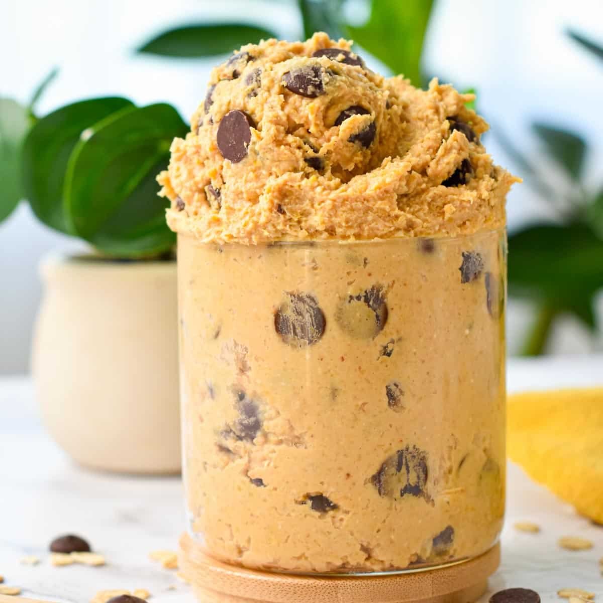 a glass jar filled with chocolate chips chickpea cookie dough