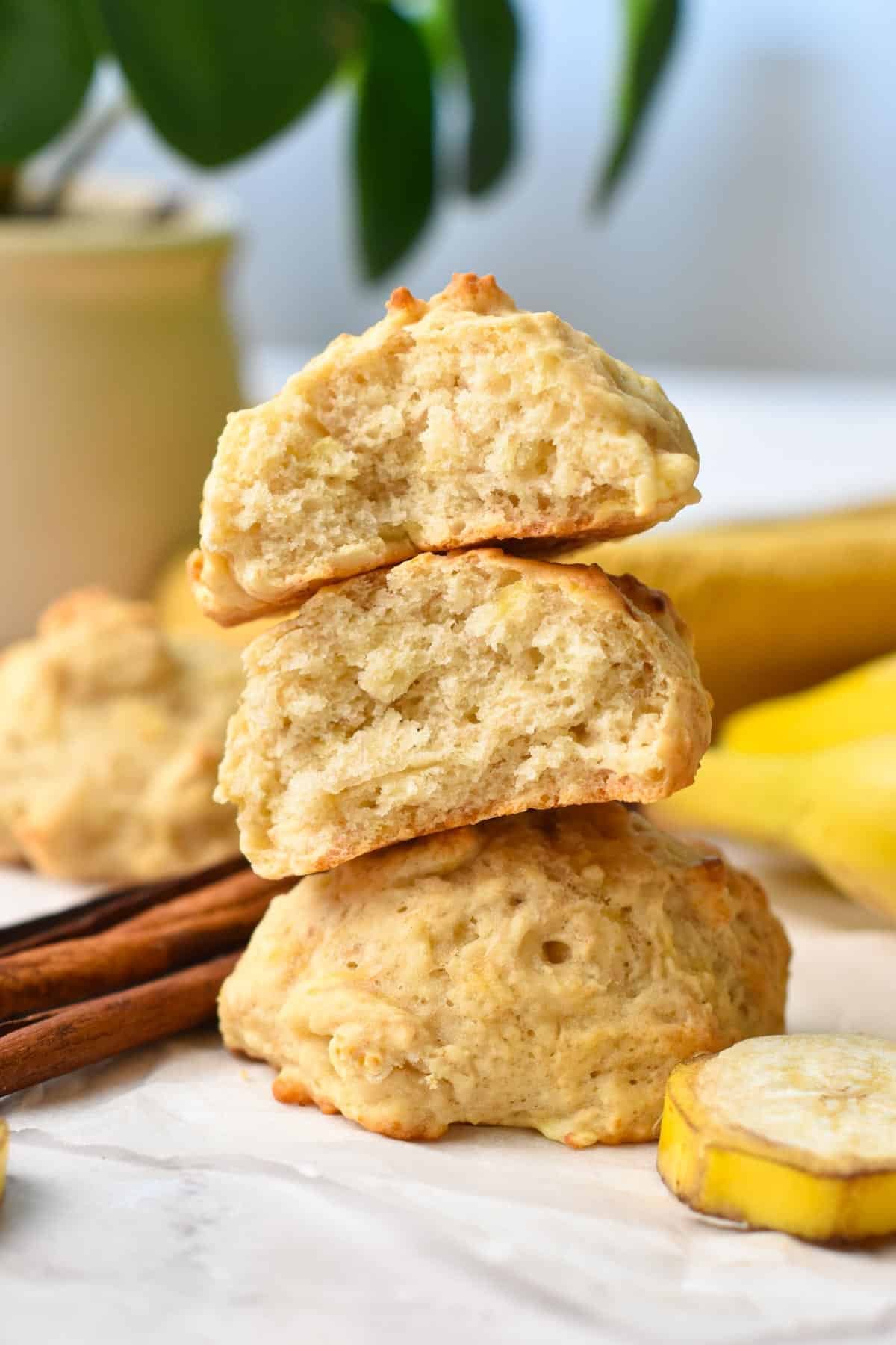 a banana cookie stack with the two pieces on top cut in half showing the fluffy cookie texture