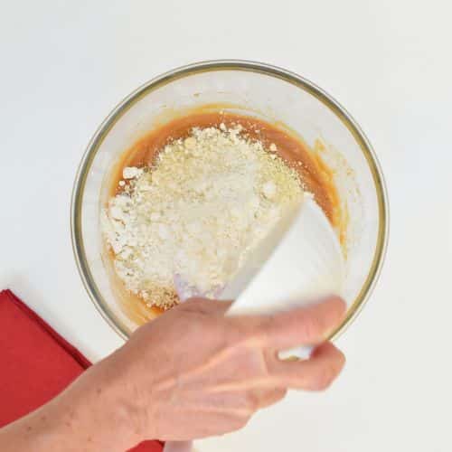 Combining Vegan Buckeye ball batter ingredients in a mixing bowl.