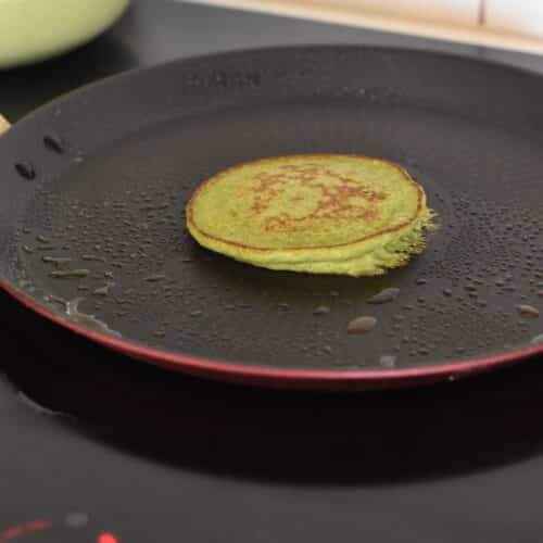 a cooked spinach banana pancake on a pancake skillet
