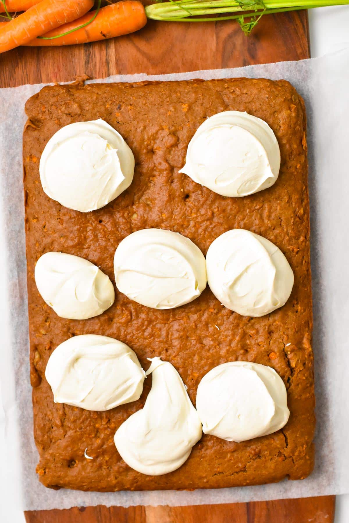 a sheet pan carrot cake with dollops of coconut cream frosting on top