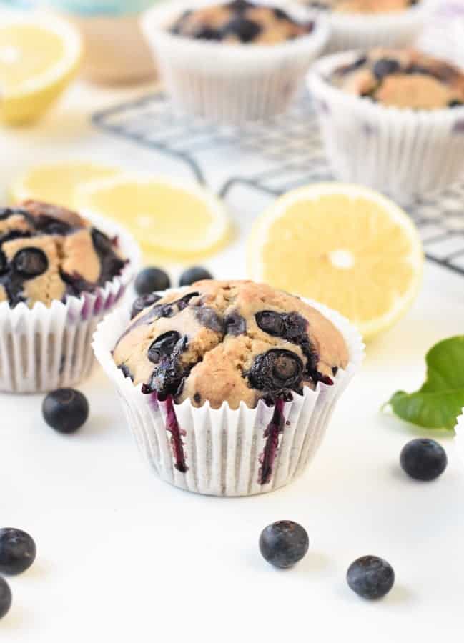 Buckwheat Muffins surrounded by blueberries and sliced lemons.