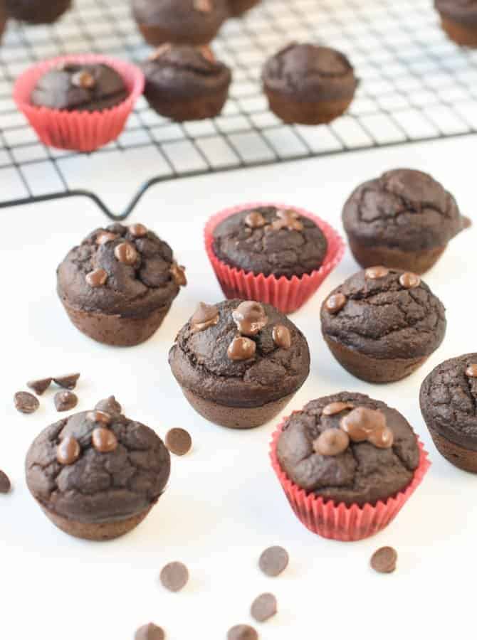 Spinach chocolate muffins cooling on a white table.