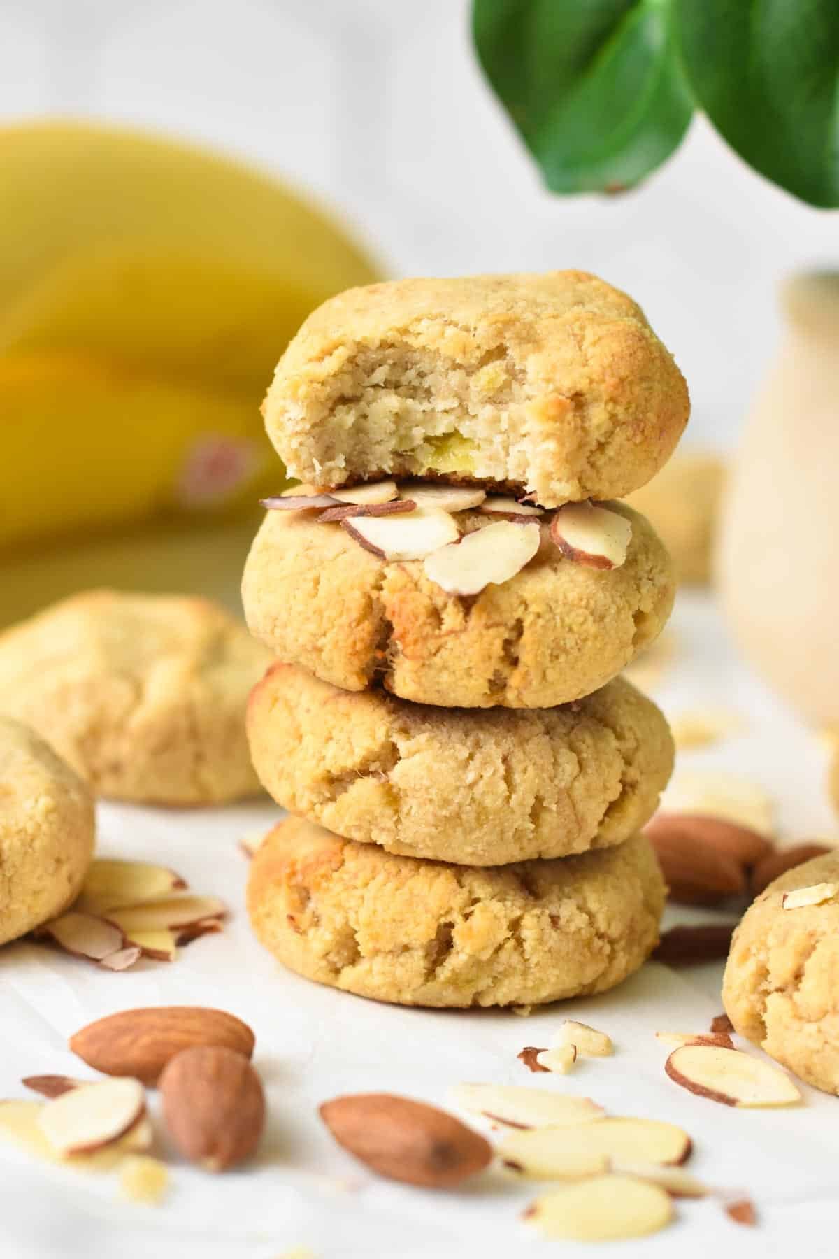 A stack of three Almond Flour Banana Cookies with the top cookie half beaten showing banana pieces in the dough.