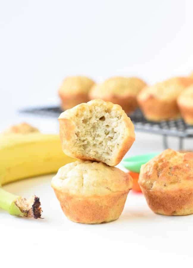 Sugar-free banana vegan muffins stacked in front of a cooling rack.