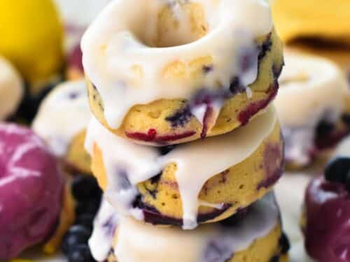 a stack of three lemon glazed blueberry donuts