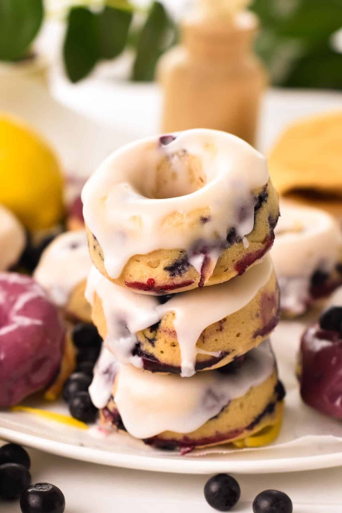 A stack of three lemon glazed blueberry donuts