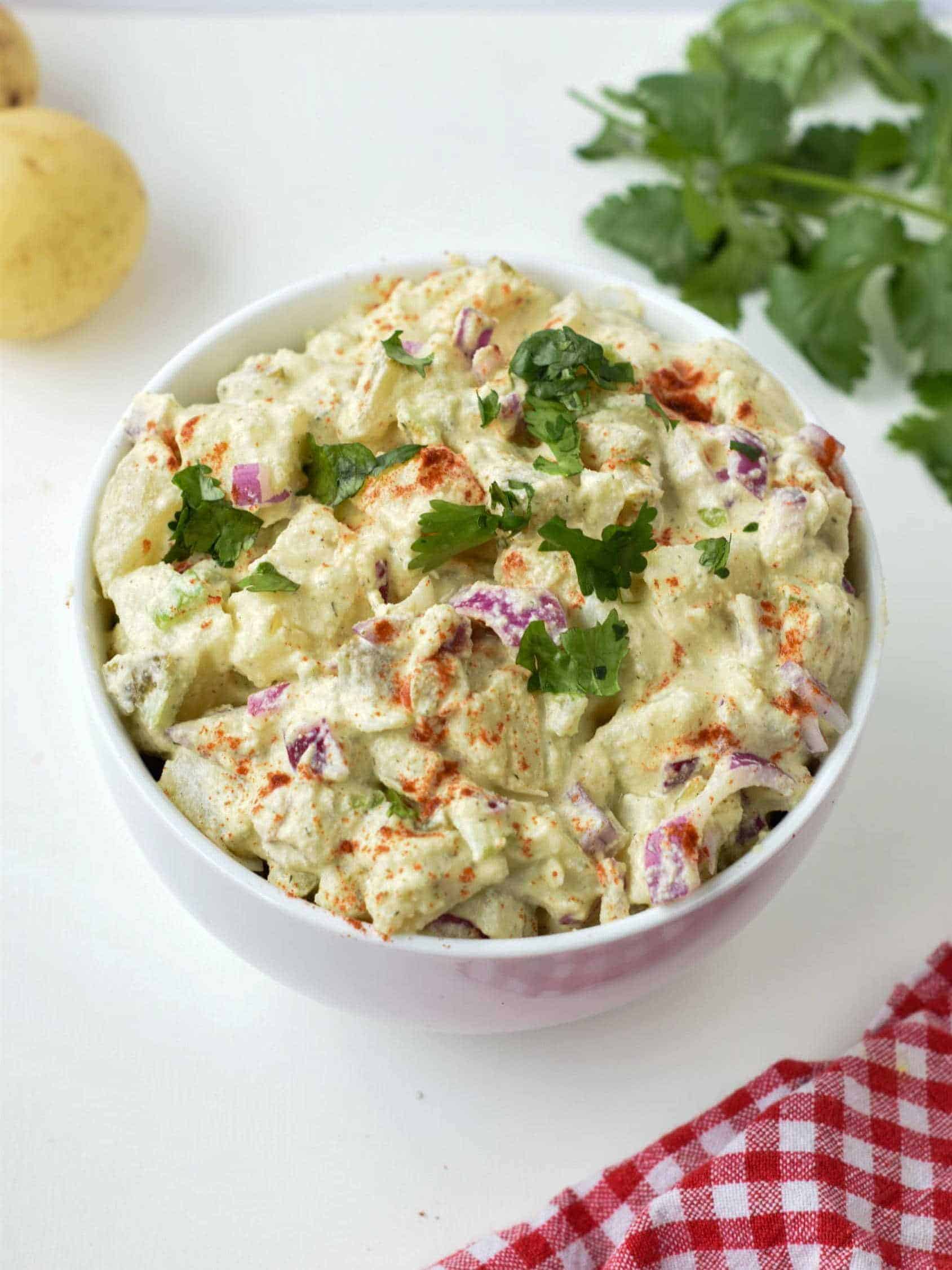 Vegan Potato Salad in a large white bowl with cilantro.
