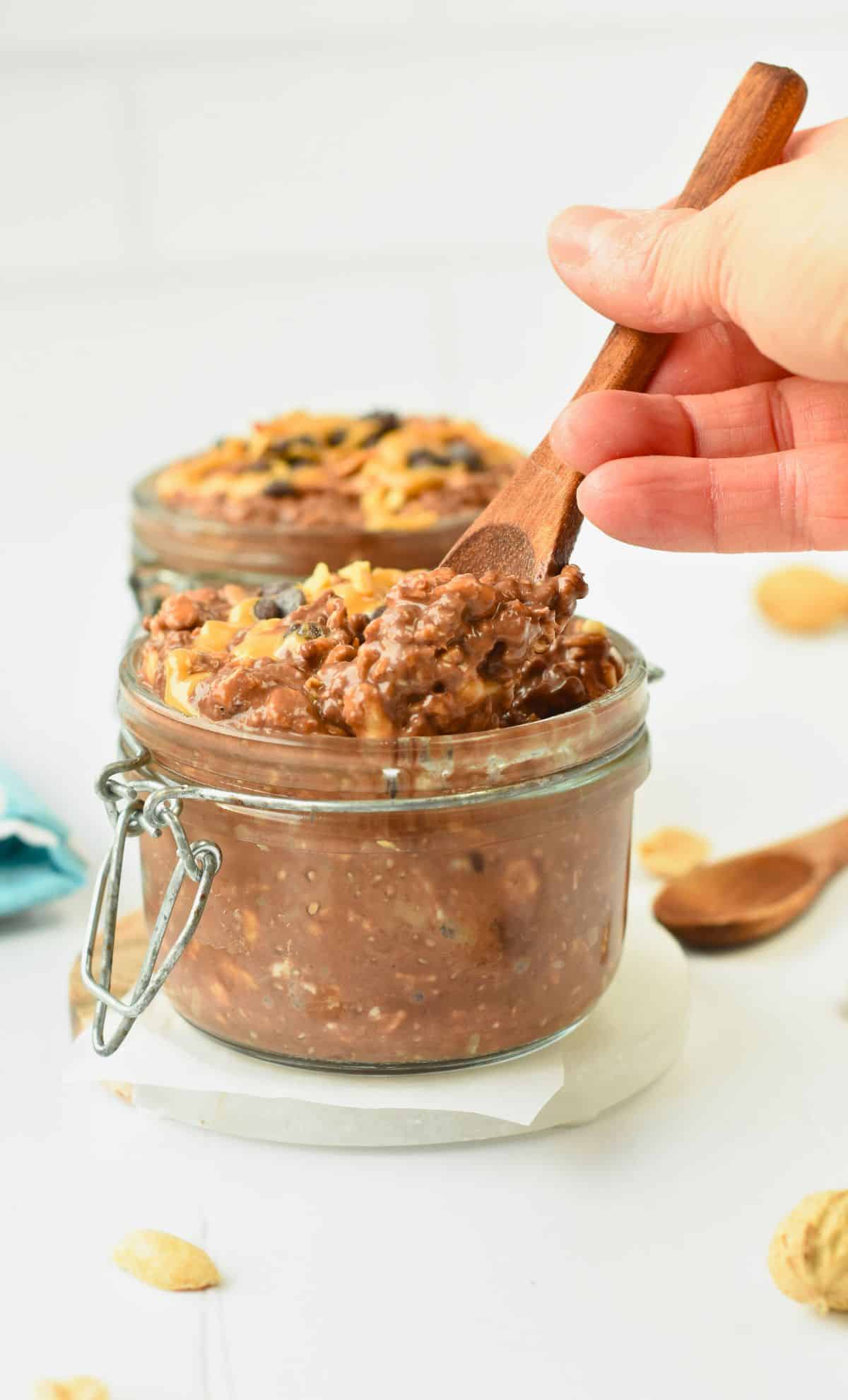 Digging a spoon in a jar full of Chocolate Overnight Oats