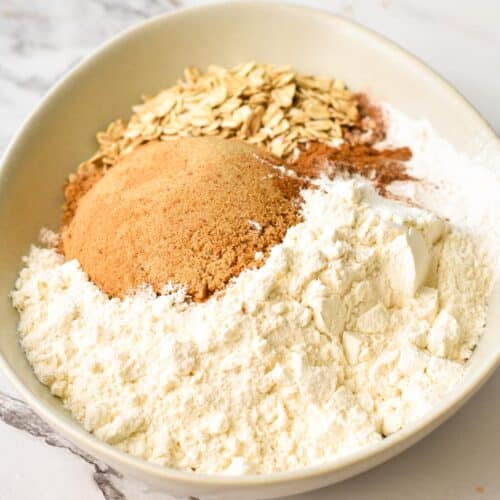 a bowl filled with dry ingredients: flour, coconut sugar, baking powder, cinnamon
