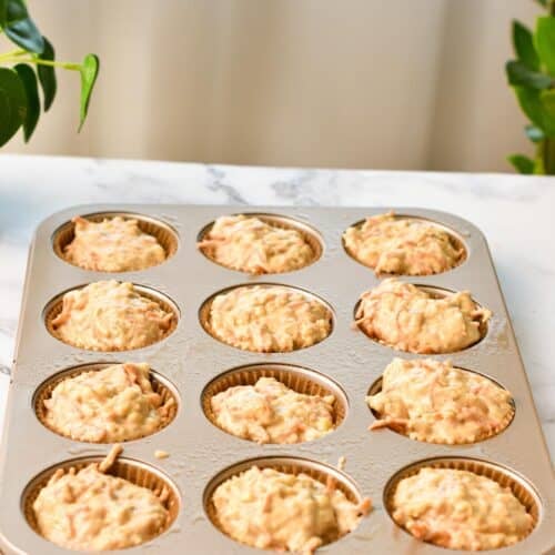 12 Banana Carrot Muffins in a muffin tray before being baked