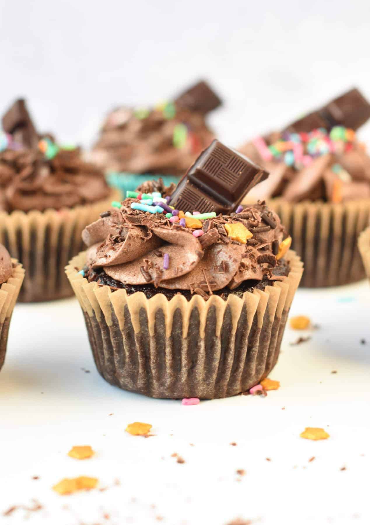 Vegan Chocolate Cupcakes decorated with vegan chocolate frosting and a chunk of vegan dark chocolate.