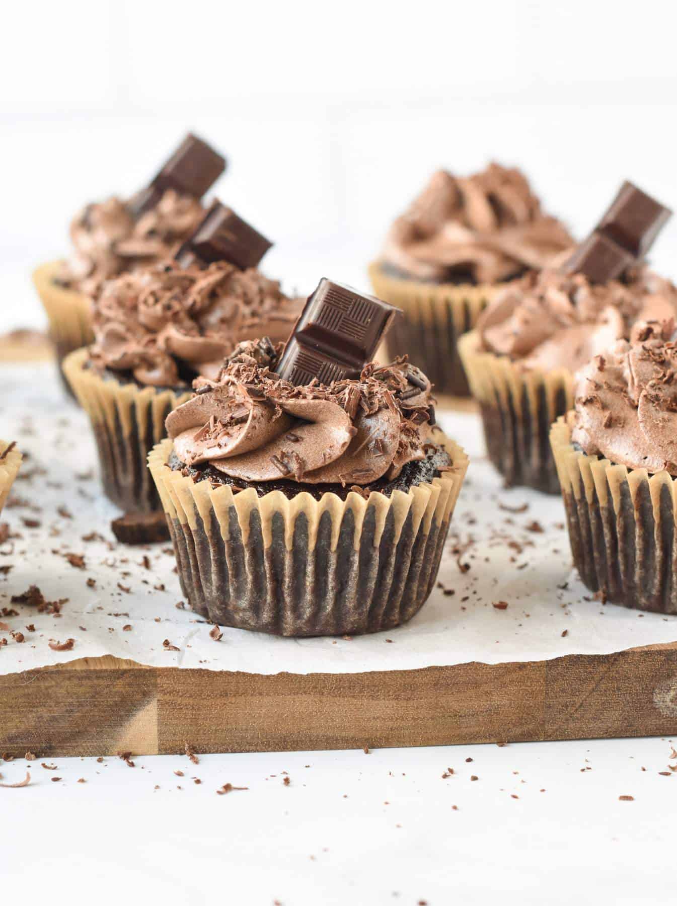 Six Vegan Chocolate Cupcakes on a chopping board.