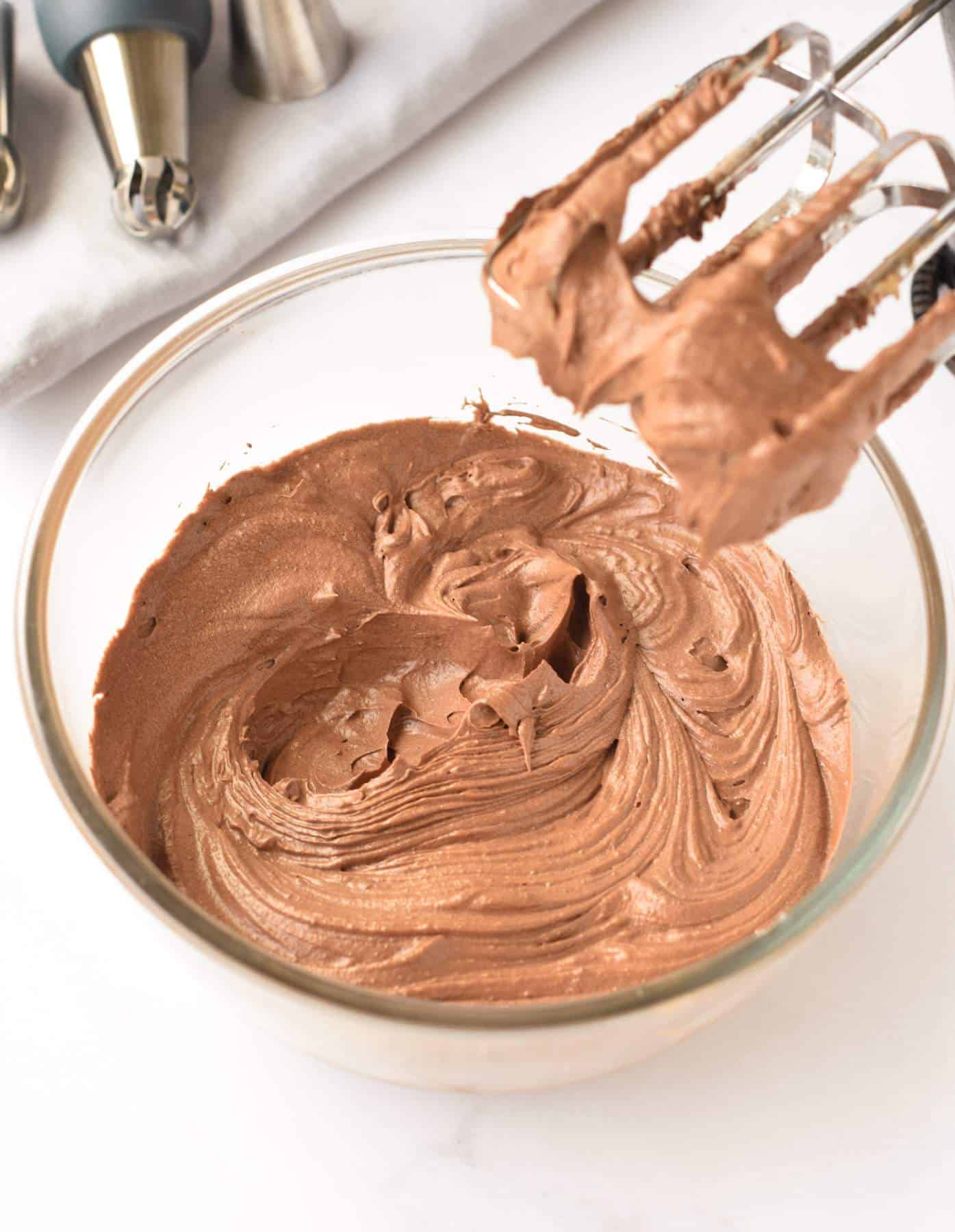 Vegan Chocolate Frosting in a mixing bowl with a mixer.