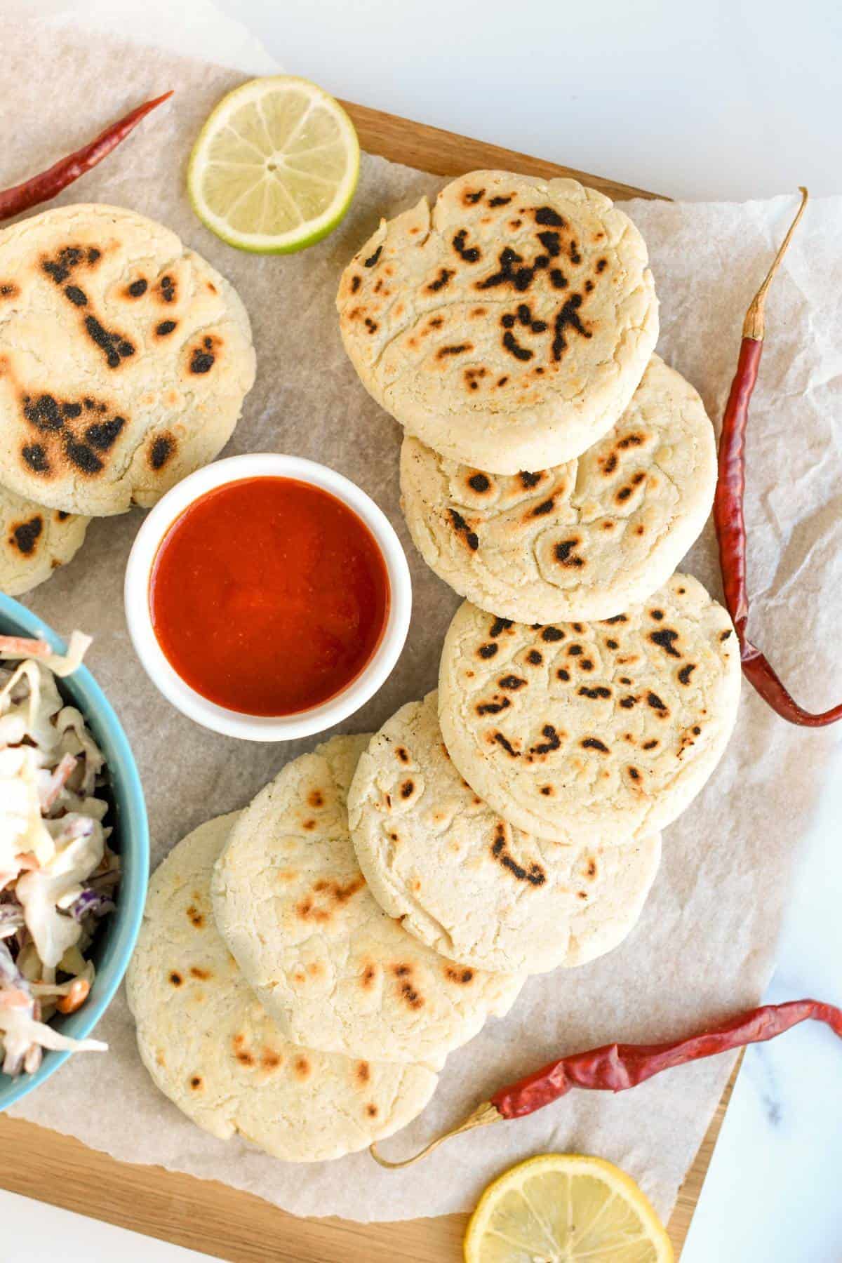 Vegan Pupusas on a chopping board and with chili and lime slices.