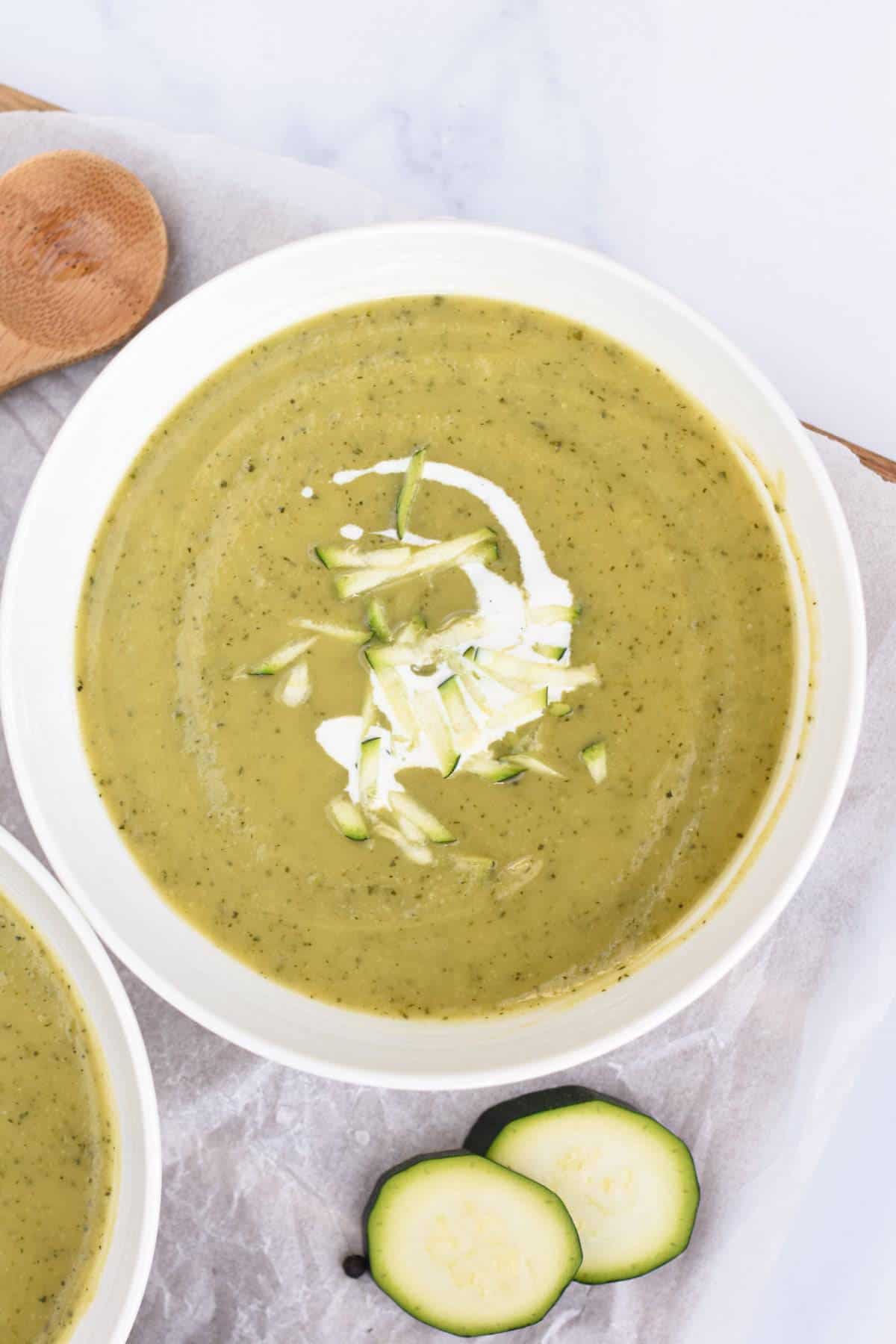 Vegan Zucchini Soup in a small bowl with a touch of coconut cream.