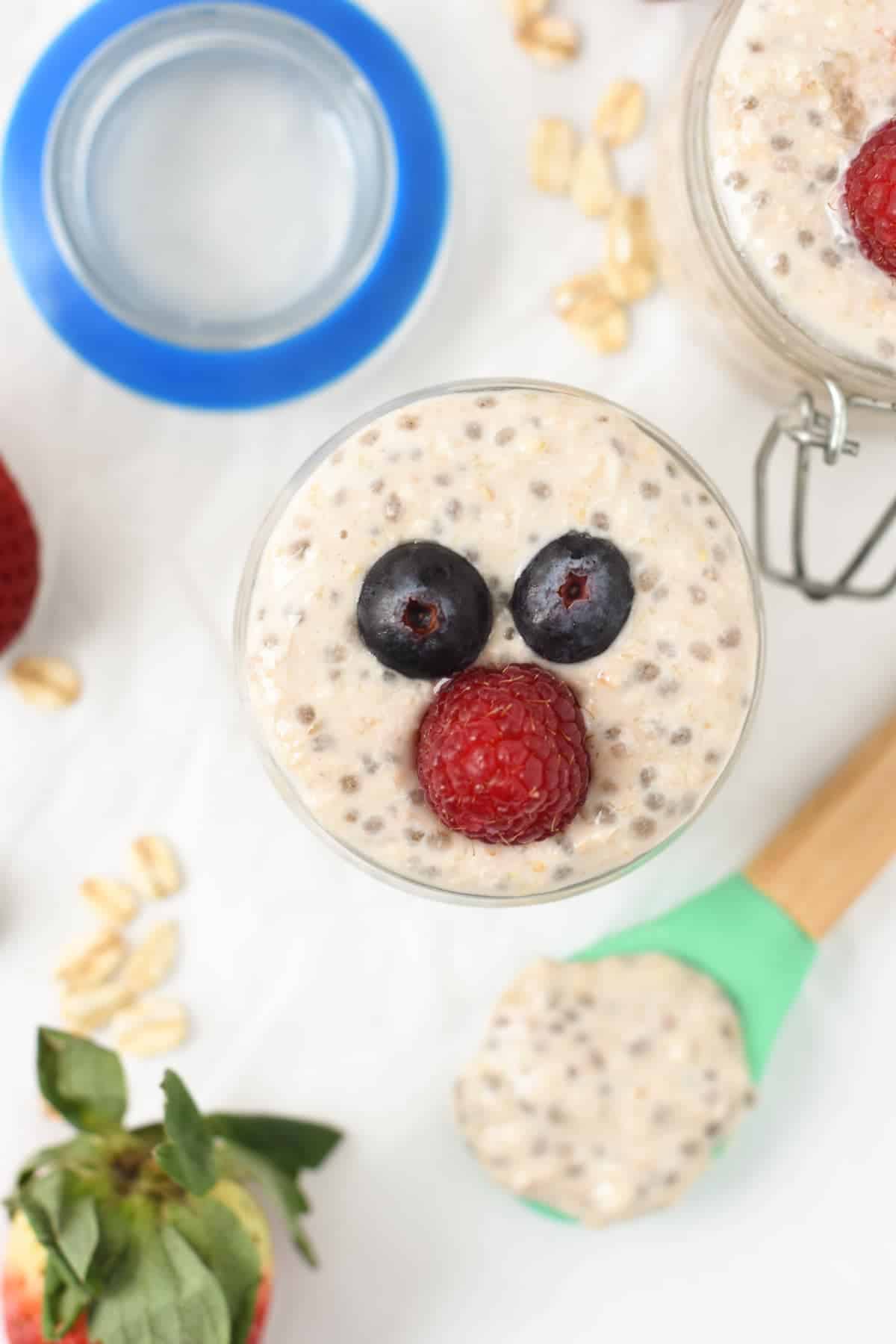 Overnight Oats for Babies in two small jars, decorated with blueberries and raspberries