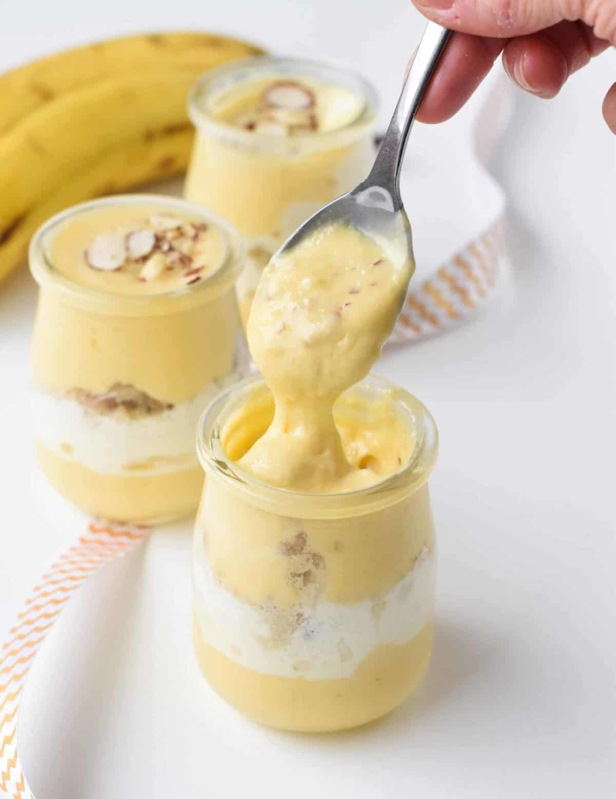 Vegan Banana Pudding served in 3 small glass jars.