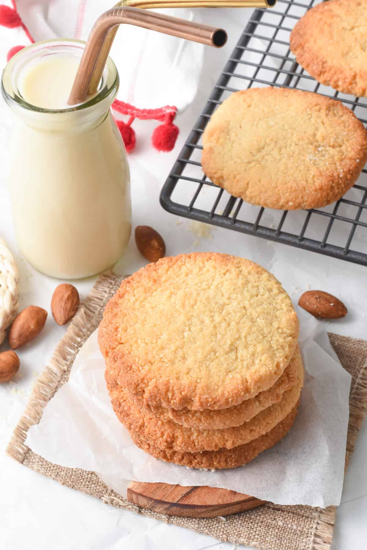 2 ingredients Cookies on a cooling rack next to a jar with almond milk.