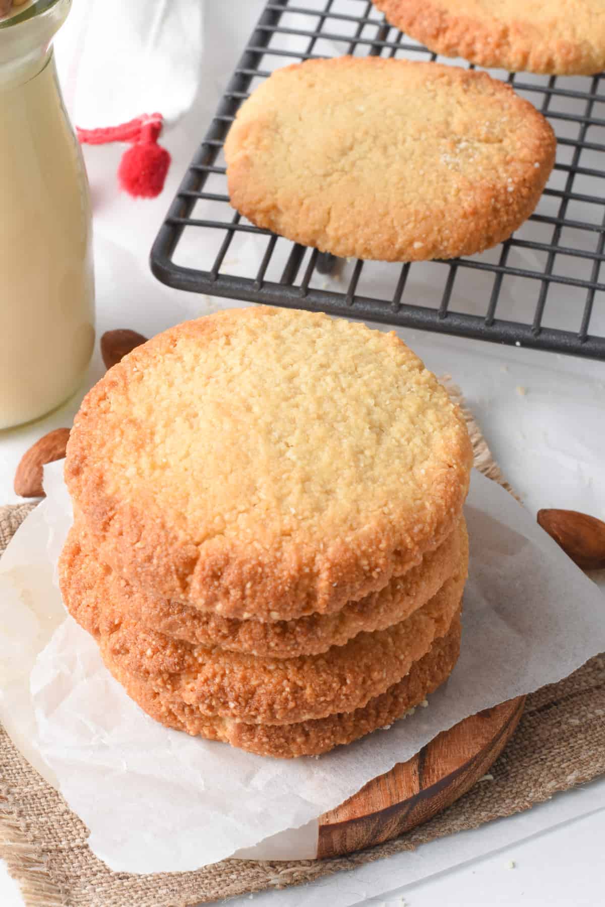 2 ingredients Cookies stacked in front of a cooling rack.