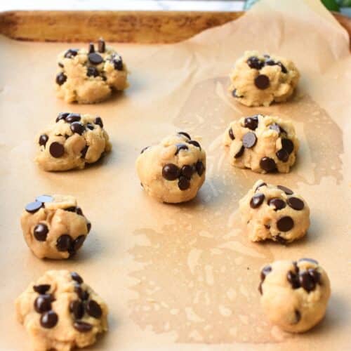almond flour chocolate chip cookie dough balls on a baking sheet covered with parchment paper