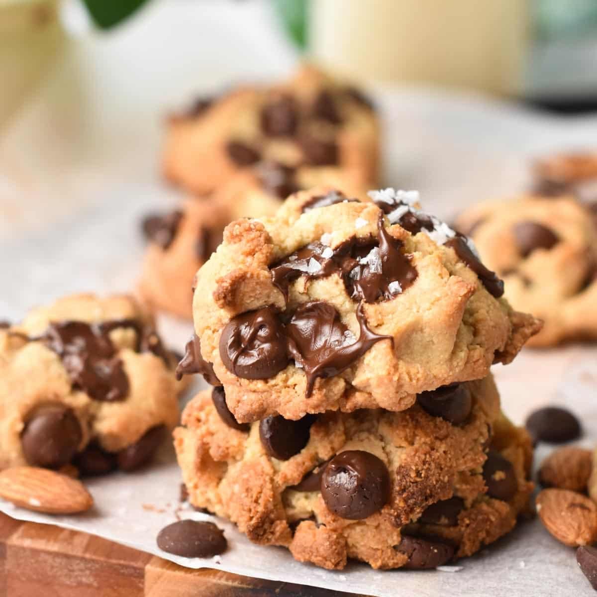 a stack of two almond flour chocolate chip cookies with a pinch of sea salt on top