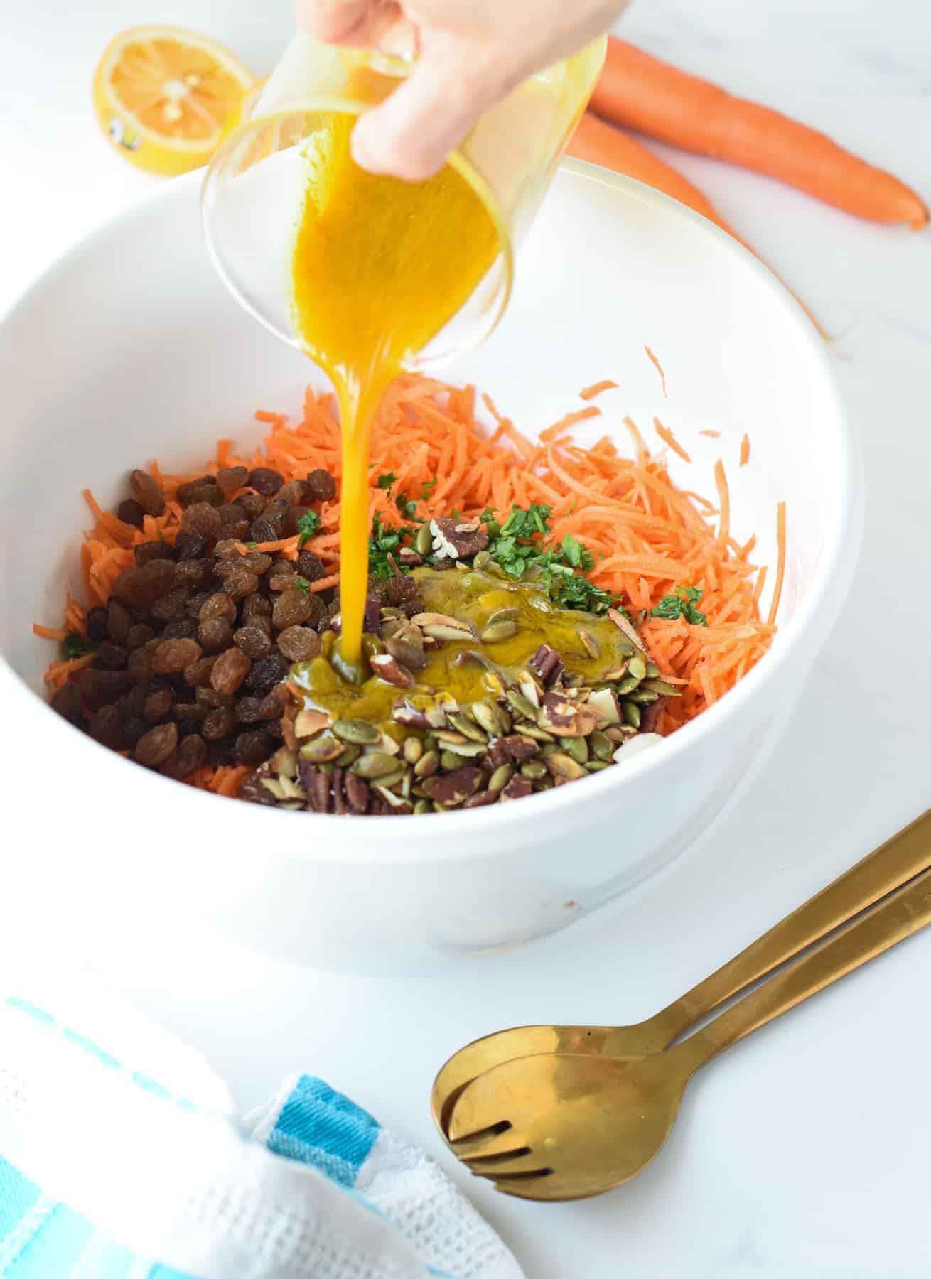 Pouring the dressing on the Carrot and Raisin Salad.