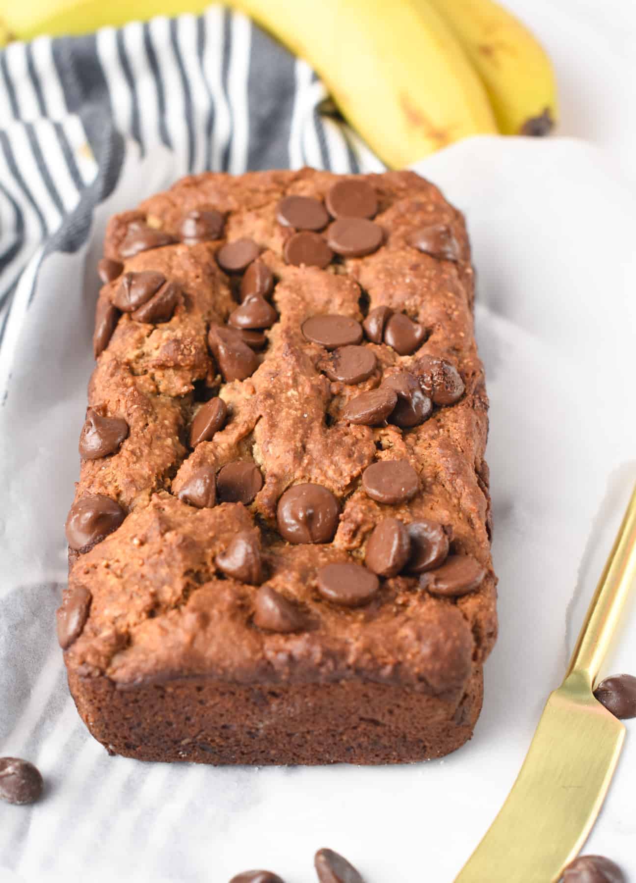 Protein Powder Banana Bread decorated with chocolate chips on a table.