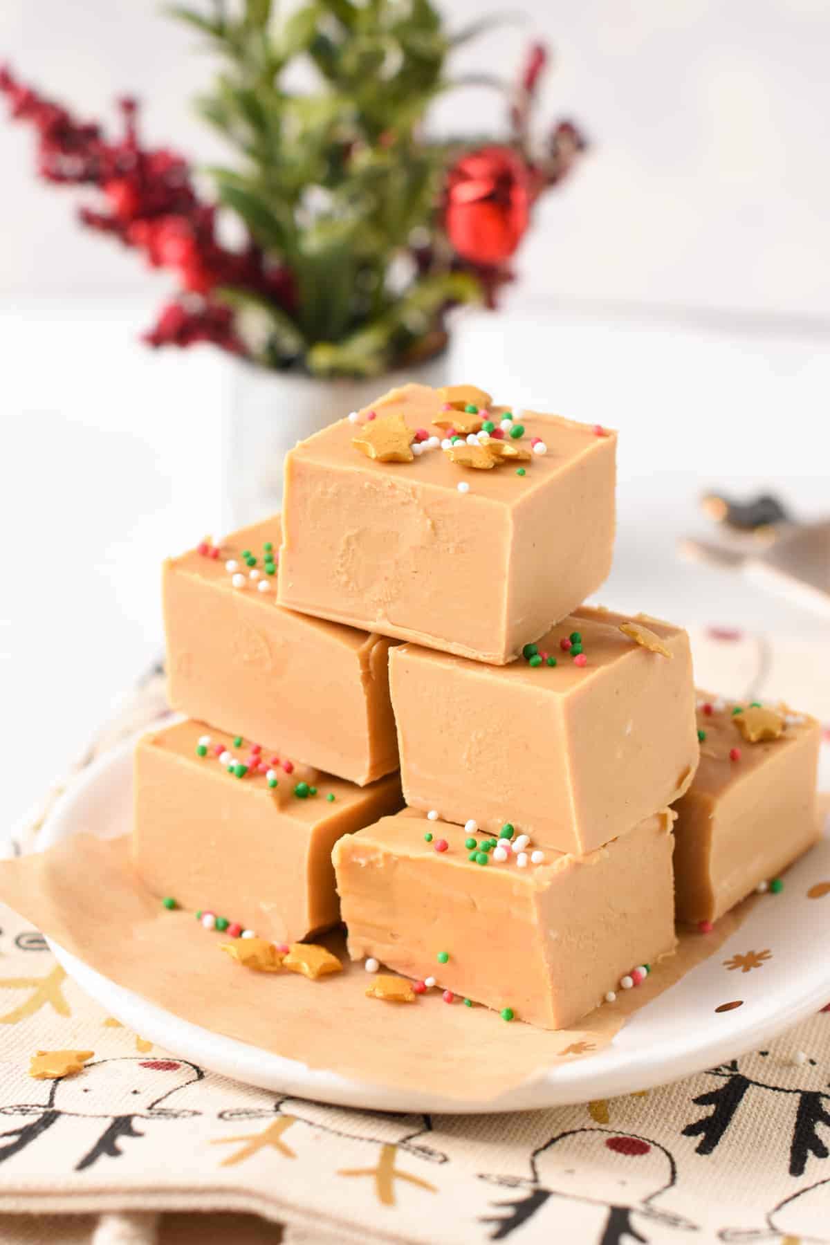 Stack of 2-ingredient Peanut Butter Fudge decorated with green, white, and red sprinkles on a small plate.