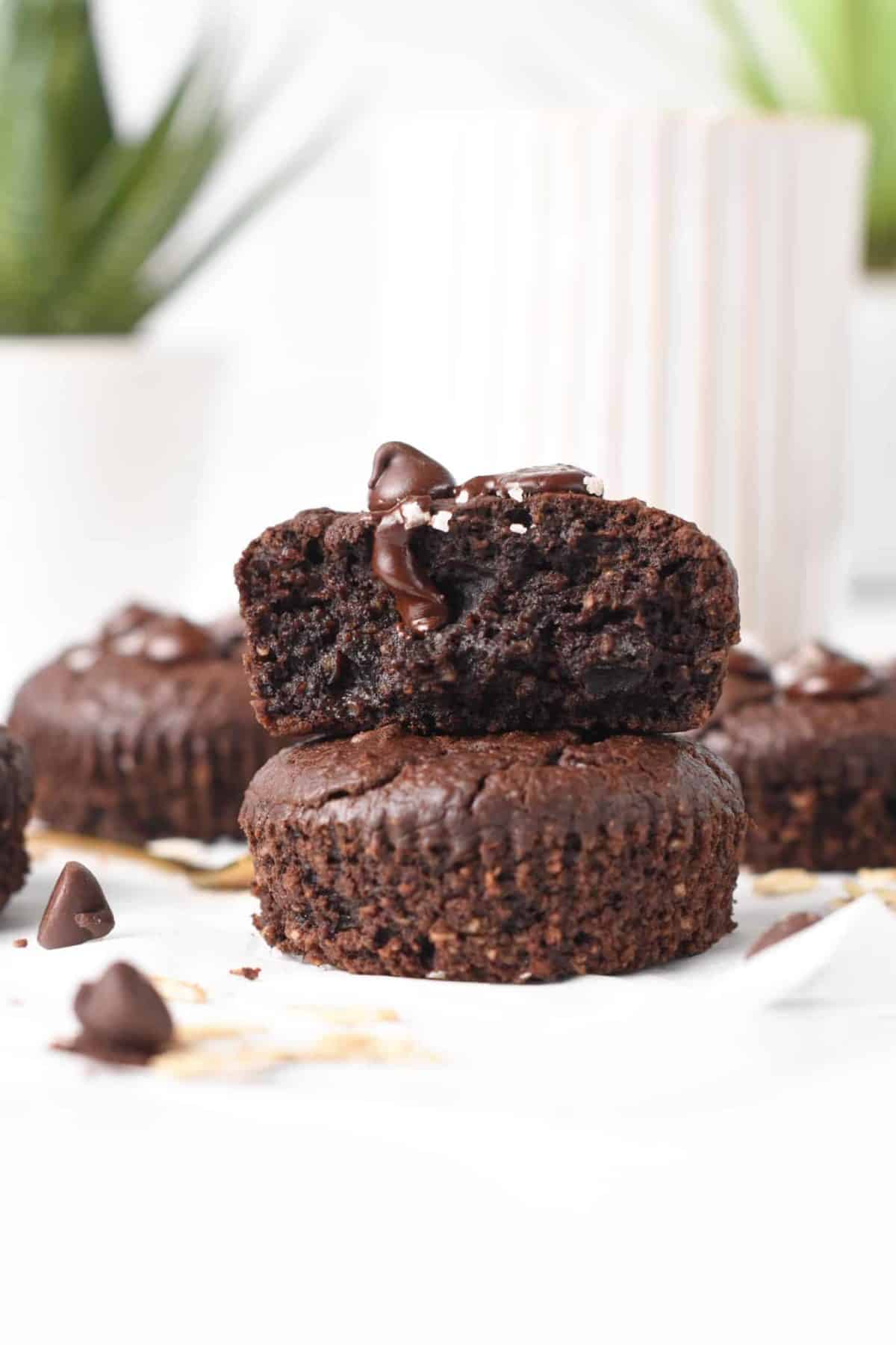 Stack of two Chocolate Protein Muffins with the top one sliced in half.