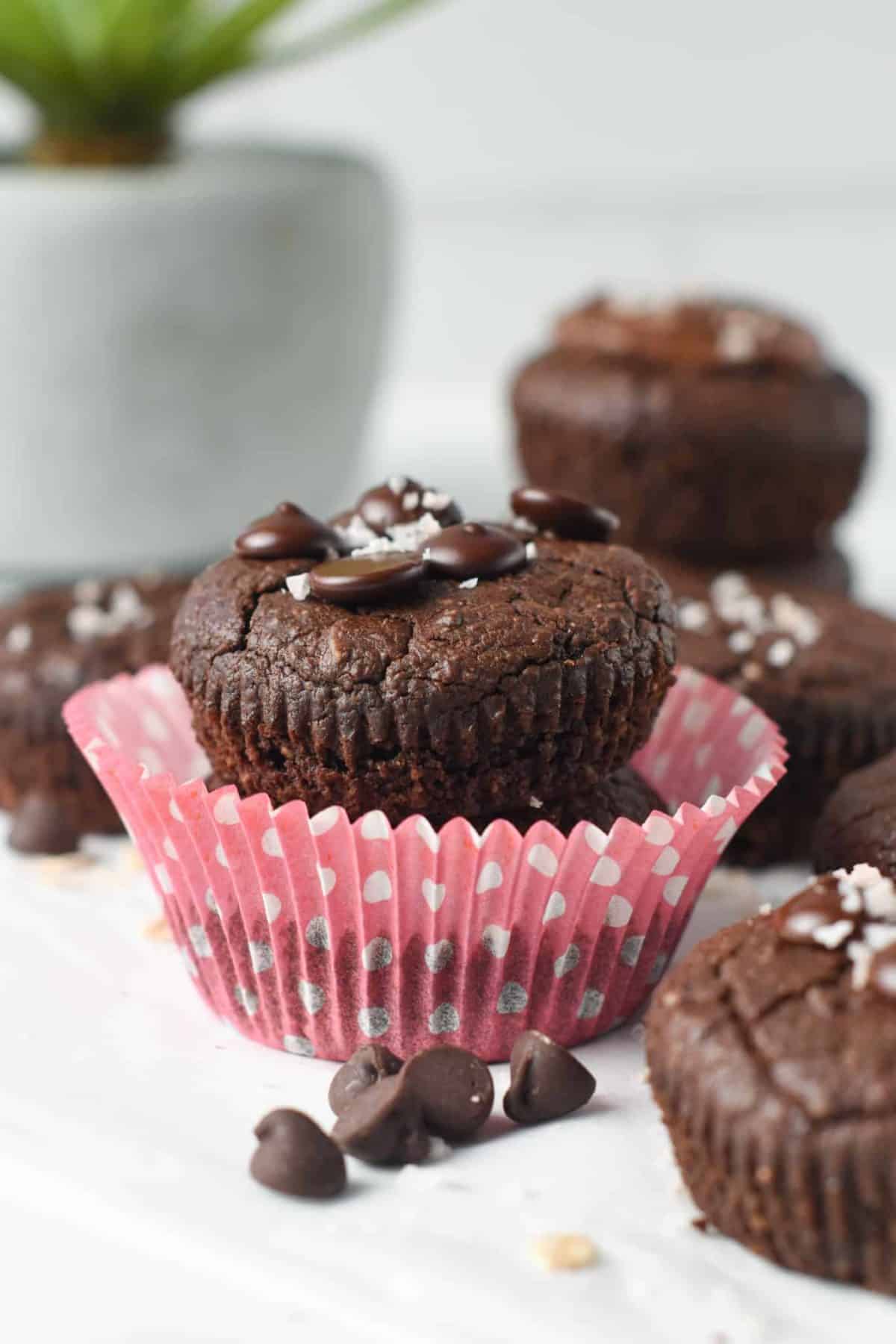 Two Chocolate Protein Muffins  stacked on a muffin cup.