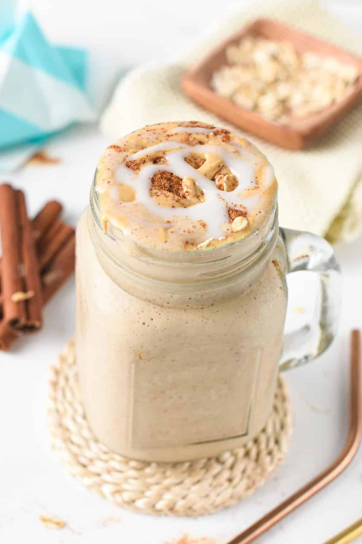 Cinnamon Roll Protein Shake on a large jar decorated with cinnamon.