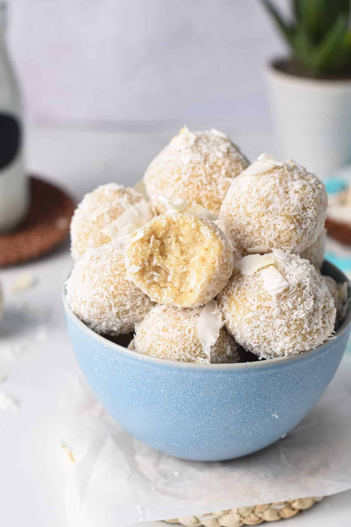 No Bake Coconut Energy Balls on a bowl with one half-bitten.