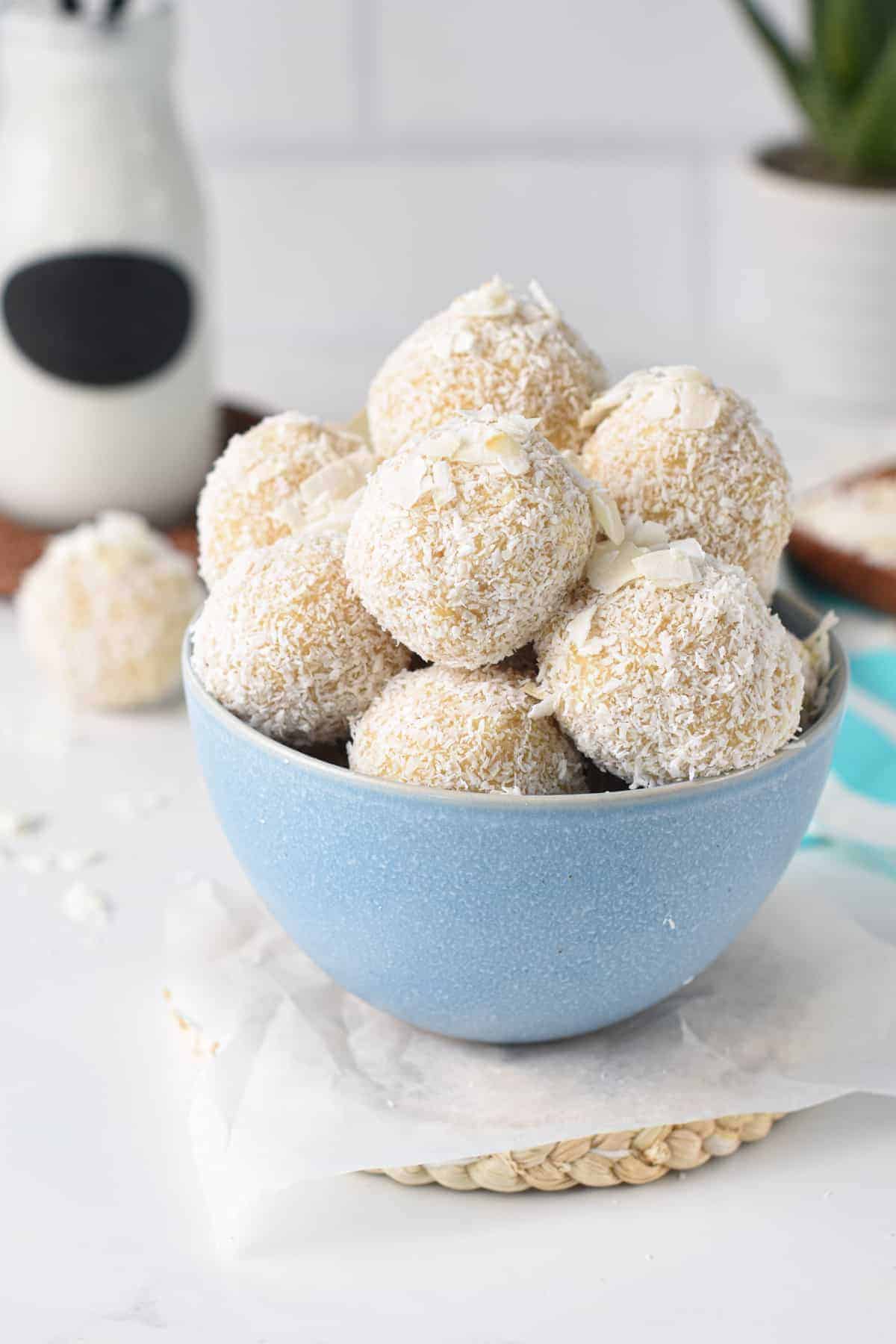 Coconut Energy Balls stacked in a blue bowl.