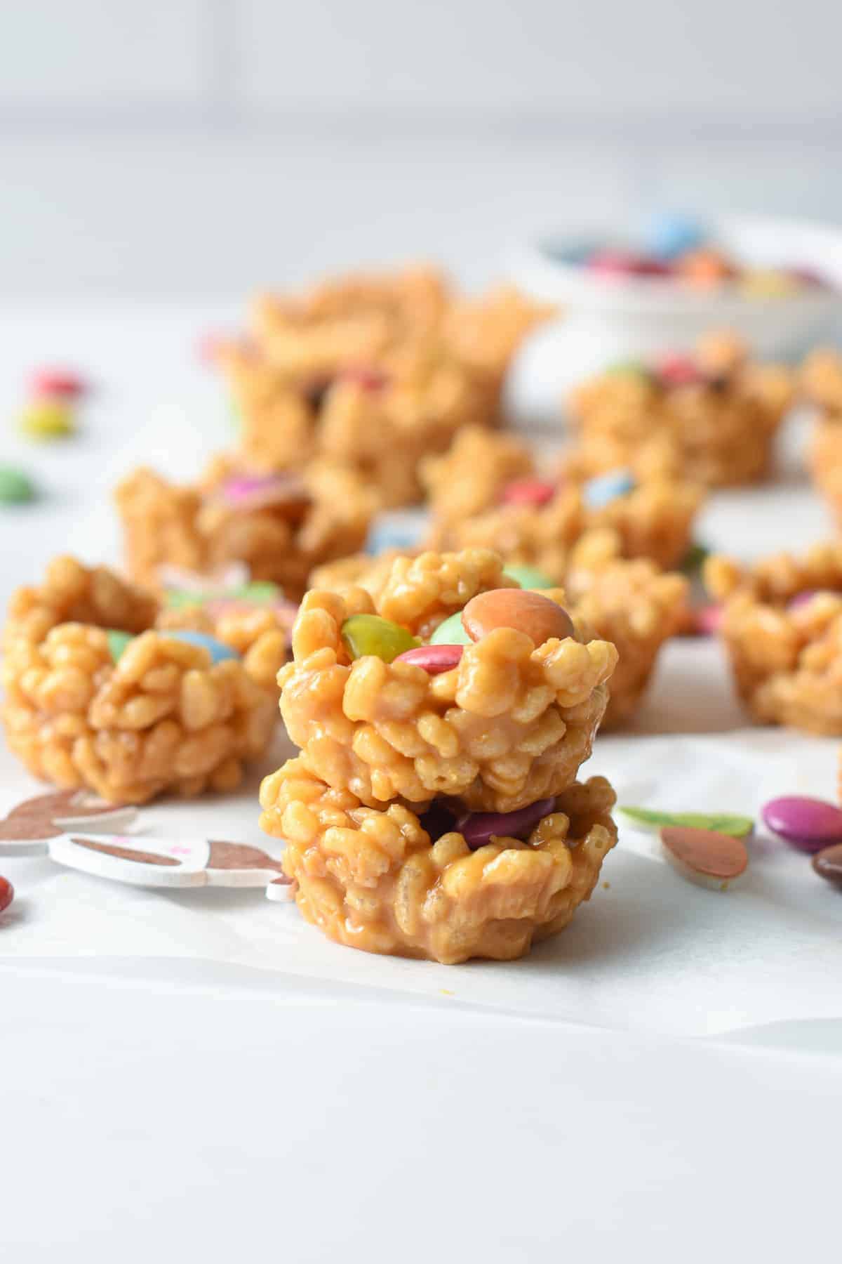 Easter Rice Krispie Nests stacked on a white tablecloth.