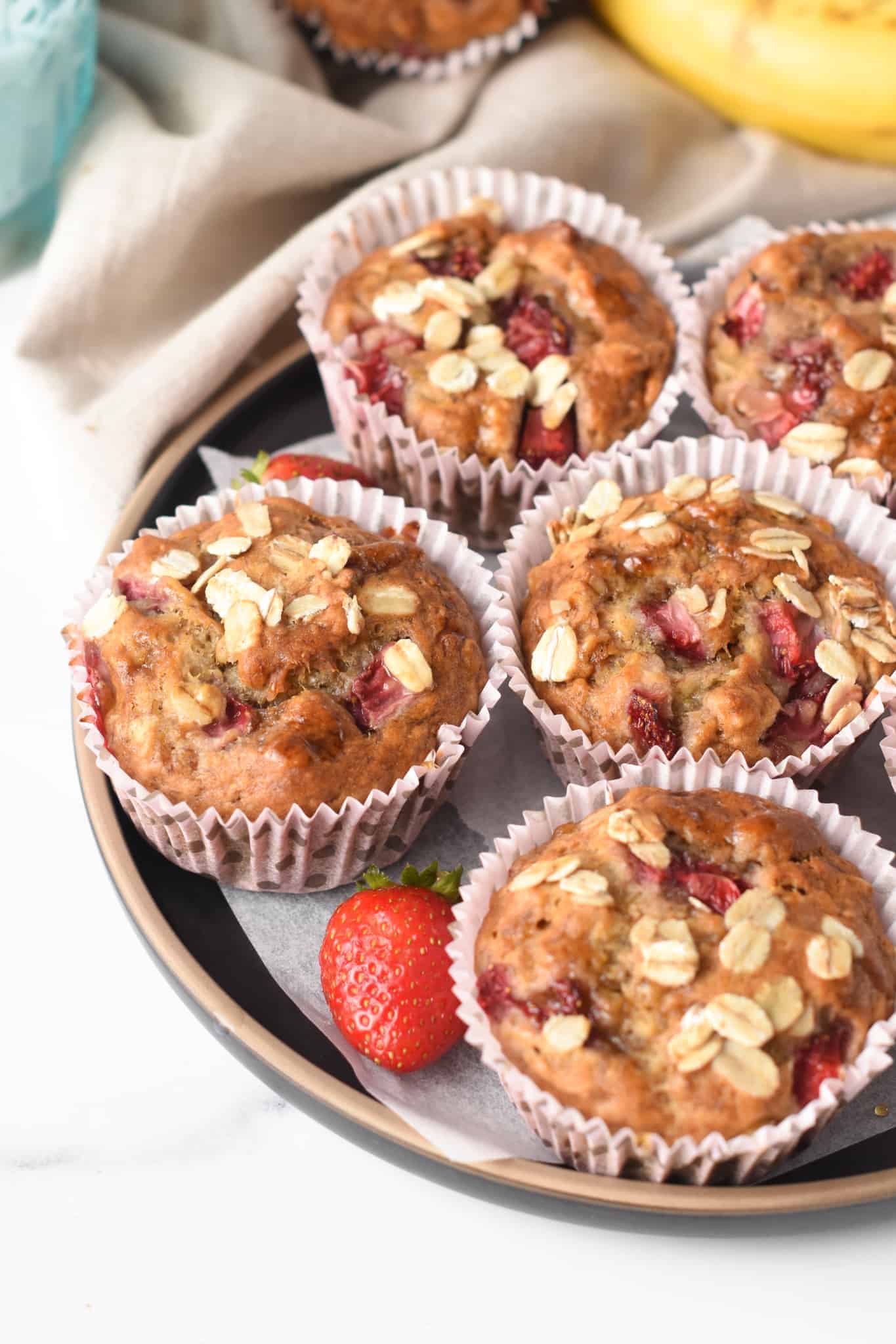 Strawberry Banana Oatmeal Muffins on a black plate.