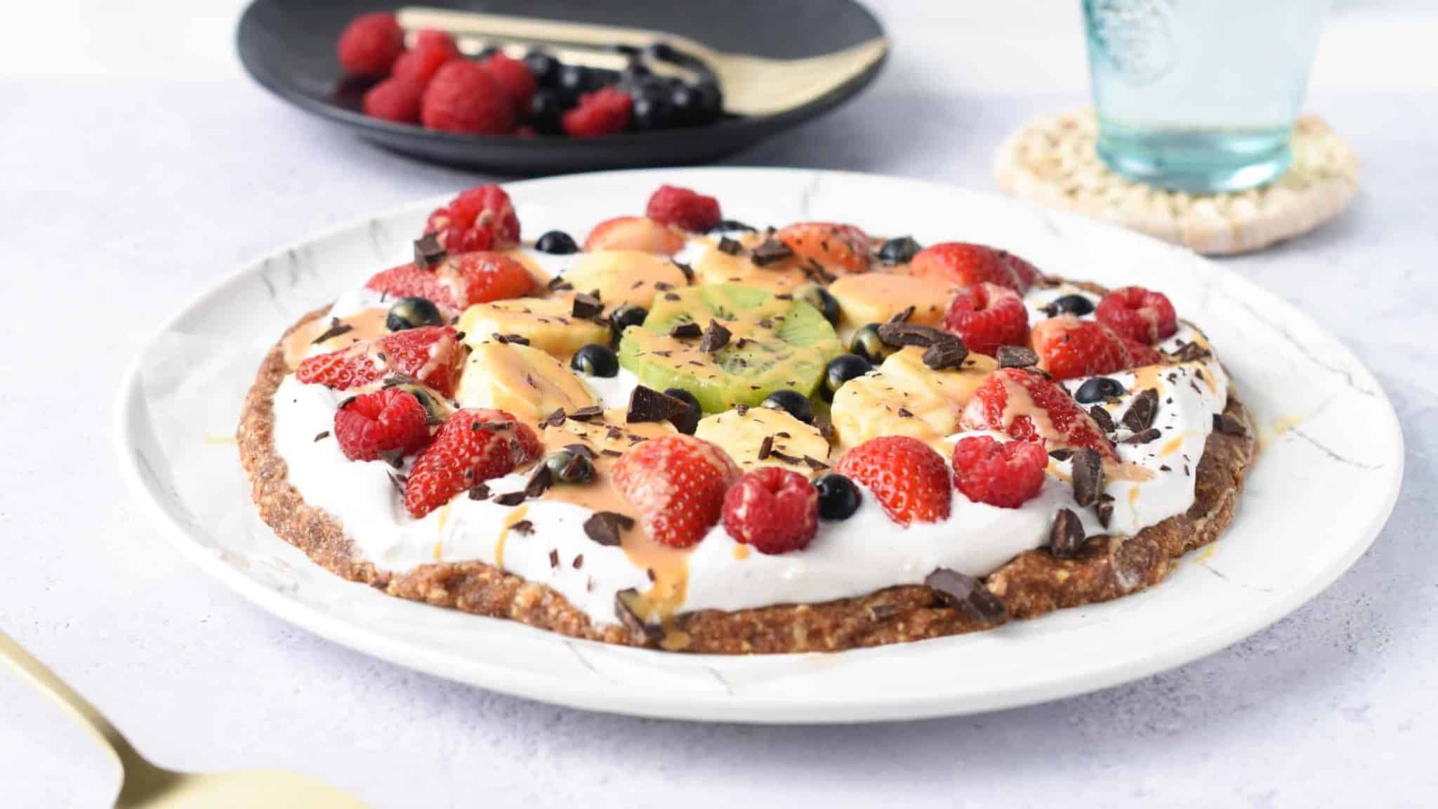 Healthy Fruit Pizza decorated with chocolate and fruits.