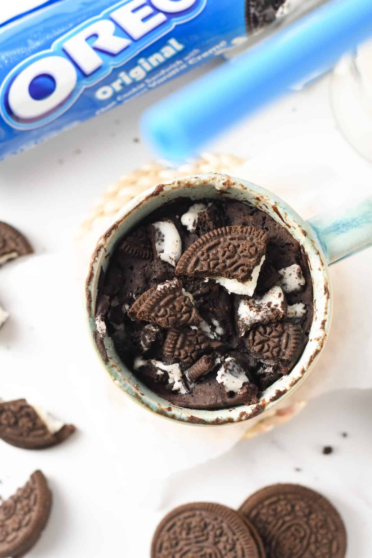 Oreo Mug Cake with a cracked Oreo on top.