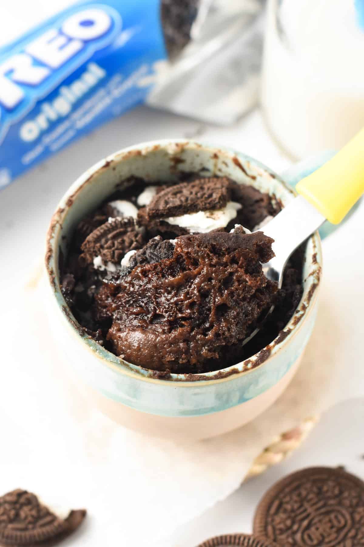 Oreo Mug Cake with a spoon taking a bite.
