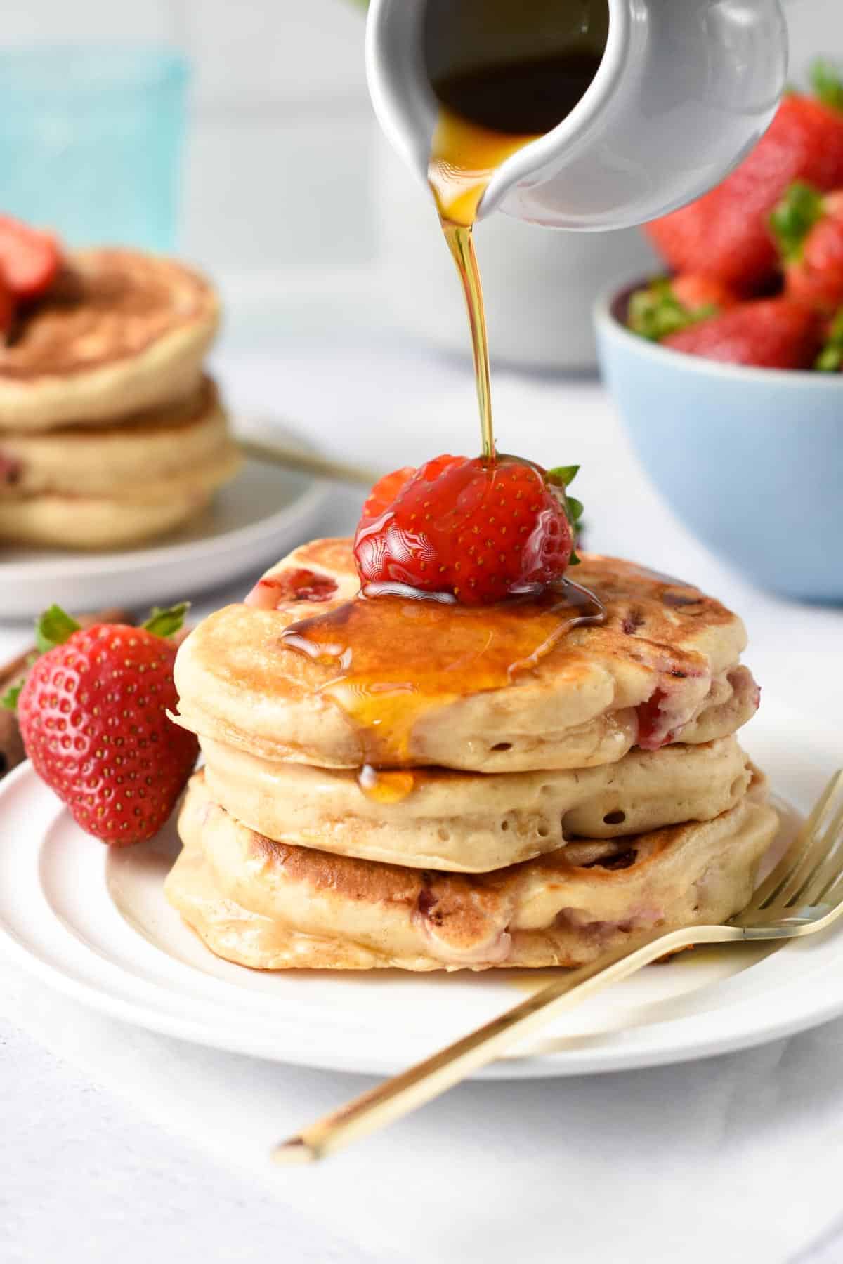 Strawberry Pancakes with maple syrup poured on them