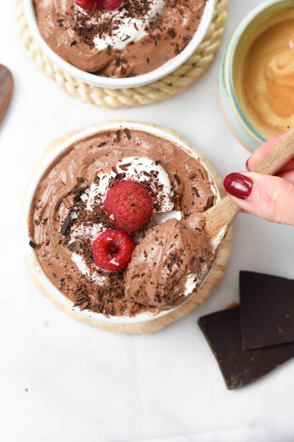 Tofu Mousse in a ramekin with a wooden spoon taking a scoop out.