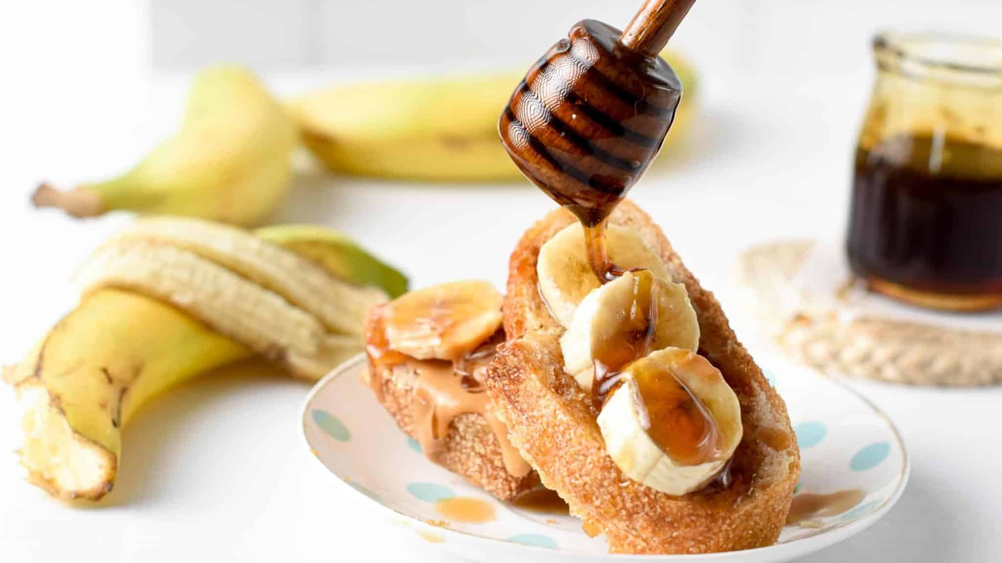 Spreading Banana Syrup on a toast with a honey dipper.